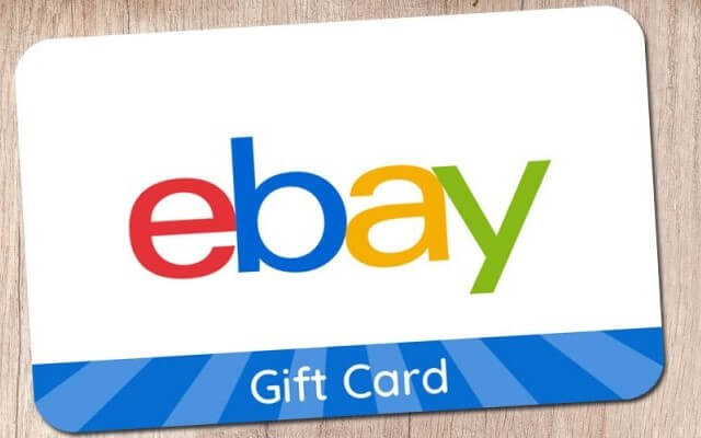 “eBay gift card with colorful logo on a wooden background”